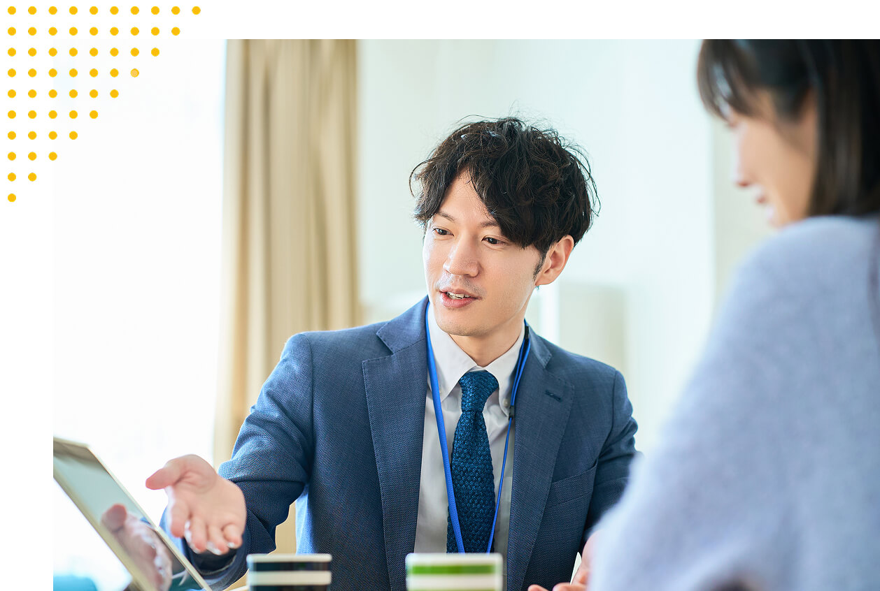 専門家の男性が女性に対して商品の説明をしている